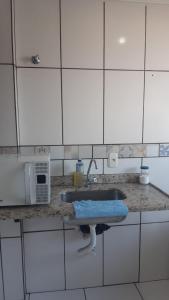 ジュイス・デ・フォーラにある130/302 AP 306 Um dois quartos dos seus sonhosのシンクと電子レンジ付きのキッチンカウンター