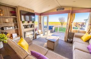 ein Wohnzimmer mit einem Sofa und einem Kamin in der Unterkunft Sea 'n' Stars Platinum Plus Holiday home with Views, Free Wifi and Netflix in Camber