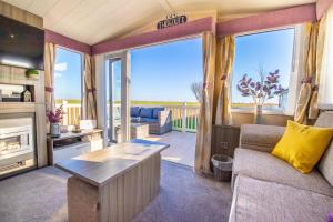 a living room with a couch and a table at Sea 'n' Stars Platinum Plus Holiday home with Views, Free Wifi and Netflix in Camber