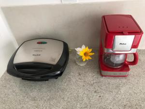 a toaster and a coffee maker and a flower at Suites Amma Noronha in Fernando de Noronha