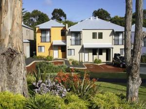 a row of houses in a yard with trees at Leeuwin Apartments in Margaret River Town