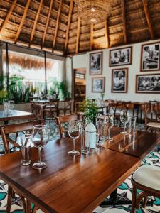 a wooden table in a restaurant with glasses on it at Blue Palm Bacalar - Adults only in Bacalar