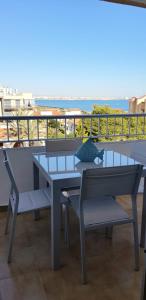 a table and chairs on a balcony with a view of the beach at Beach Front Sea View Punta Prima in Punta Prima