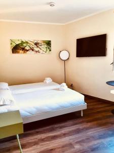 um quarto de hotel com duas camas e uma televisão de ecrã plano em The Square of Miracles Apartment em Pisa
