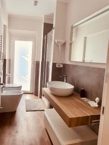 a bathroom with two sinks and a large mirror at The Square of Miracles Apartment in Pisa
