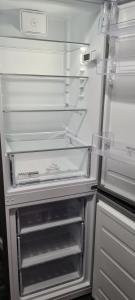 an empty refrigerator with its door open in a kitchen at Appartement 65m² Paris - DisneyLand - RER A in Noisy-le-Grand