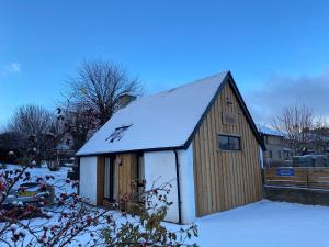 un piccolo edificio in legno con la neve sopra di Butterfly Cottage a Grantown on Spey