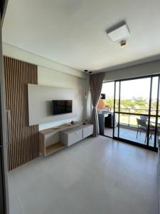 a living room with a flat screen tv on a wall at Flat 208 Eco Resort Carneiros in Tamandaré