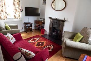 a living room with a red couch and a fireplace at Anvil Lodge in Goulsby