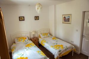 Anvil Lodge في Goulsby: سريرين في غرفة بجدران بيضاء