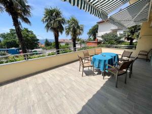 patio con mesa azul y sillas en el balcón en Apartments in Crikvenica 42053, en Crikvenica