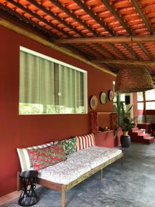 un sofá en una habitación con una pared roja en Grand Casa Rossa, en Morro de São Paulo