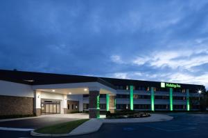 ein Krankenhausgebäude mit grüner Beleuchtung auf einem Parkplatz in der Unterkunft Holiday Inn - Long Island - ISLIP Arpt East, an IHG Hotel in Holtsville
