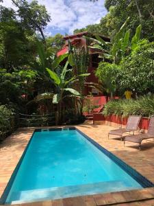 una piscina con 2 sillas y una casa en Grand Casa Rossa, en Morro de São Paulo