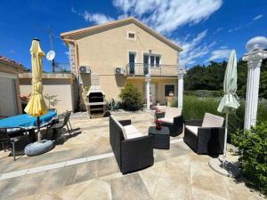 a patio with a table and chairs and umbrellas at Holiday home in Jadranovo 42254 in Jadranovo