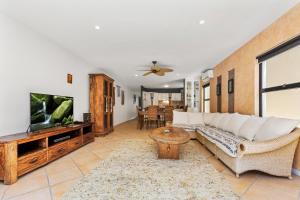 ein Wohnzimmer mit einem Sofa und einem Flachbild-TV in der Unterkunft Villa Baci Nobby Beach in Gold Coast