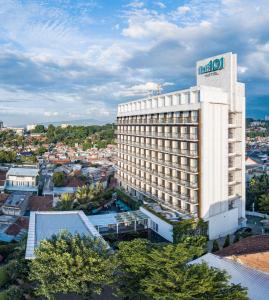 un bâtiment d'hôtel avec un panneau en haut dans l'établissement THE 1O1 Bogor Suryakancana, à Bogor