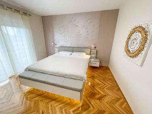 Schlafzimmer mit einem Bett und Holzboden in der Unterkunft Apartment in Crikvenica 42248 in Crikvenica