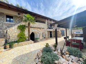 ein Steinhaus mit einer Terrasse mit einem Tisch und Stühlen in der Unterkunft Holiday home in Bribir 42275 in Bribir