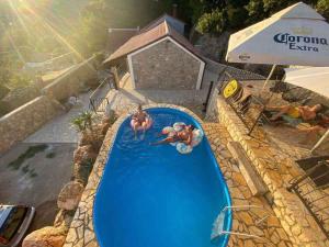 duas pessoas a nadar numa piscina num resort em Holiday home in Bribir 42275 em Bribir