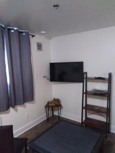 sala de estar con TV de pantalla plana en la pared en Black Rooster Guesthouse, en Prince Rupert