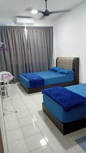 una camera con due letti e una sedia di Pangsapuri Ladang Tanjung a Kuala Terengganu