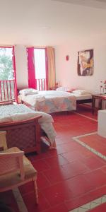 サレントにあるHotel Natura Cocoraの赤いタイルフロアの客室で、ベッド2台が備わります。