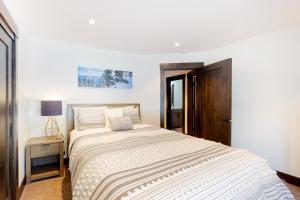 a white bedroom with a large bed and a table at Maison de Montagne in Incline Village