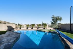 ein Pool in einem Garten mit einem Zaun in der Unterkunft Living Under Par in Phoenix