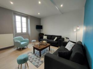 ein Wohnzimmer mit einem Sofa und einem Tisch in der Unterkunft Gîte Saint-Haon-le-Châtel, 4 pièces, 11 personnes - FR-1-496-252 in Saint-Haon-le-Châtel
