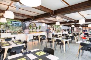 un restaurante con mesas y sillas y gente de fondo en Holiday Homes in Piombino - Toskana 42359, en Piombino
