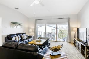 a living room with a black leather couch and a table at Gulf Getaway in Clearwater Beach