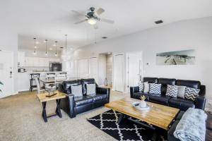 a living room with black leather furniture and a table at Gulf Getaway in Clearwater Beach