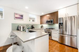 a kitchen with white cabinets and a stainless steel refrigerator at City-View Modern in Seattle