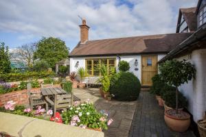 una casa con un jardín con flores y plantas en Bay Tree Cottage, en Droitwich