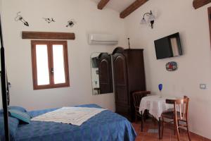 a bedroom with a bed and a table and a window at La Casa del Geko in Cefalù