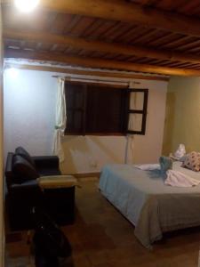 a bedroom with a bed and a chair and a window at Architerra in San Javier