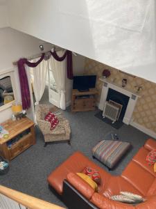 a living room with a couch and a fireplace at Long Meadow Bakery in Pembrokeshire