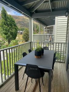 a table and chairs on a porch with a view at Cardrona Mountain Villa in Cardrona