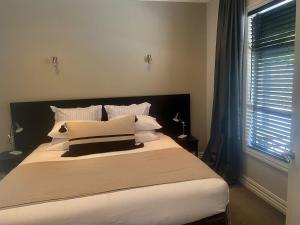a bedroom with a large bed with white sheets and pillows at Cardrona Mountain Villa in Cardrona