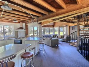 a kitchen and living room with wooden ceilings at Banjo's Chalet, alpine-getaways in Dinner Plain