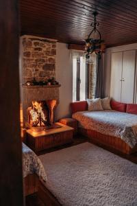 um quarto com uma lareira, uma cama e um sofá em The Traditional Greek House em Ioannina