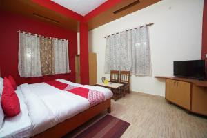 Plaza Hotel في Pithorāgarh: غرفة نوم بسرير وتلفزيون بشاشة مسطحة