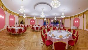 un salón de banquetes con mesas, sillas y lámparas de araña en Villa Bergera, en Dzierżoniów