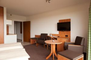 a hotel room with a bed and a table and chairs at Hotel Haus Deutsch Krone in Bad Essen