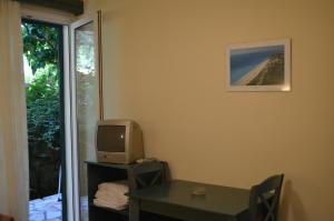 a room with a table with a tv and a desk with a computer at Odysseia Apartments in Nikiana