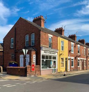 an old brick building on a street with a store at The Victoria - Quaint Victorian Home With Free Parking in York