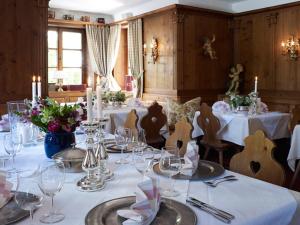 a dining room with tables and chairs with white tablecloths at Alte Posthalterei Zorneding in Zorneding
