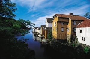 a row of houses next to a river at Peaceful Riverfront Home with Views in Ålgård