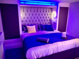 a purple bedroom with a large bed with a purple lighting at Saltrock luxury apartment in Blackpool